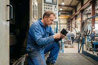 Technicien en overalls utilisant un videoscope dans une usine